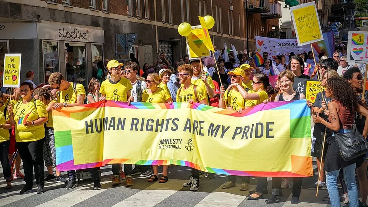 Deltagare i Stockholm Pride med en banderoll om mänskliga rättigheter.